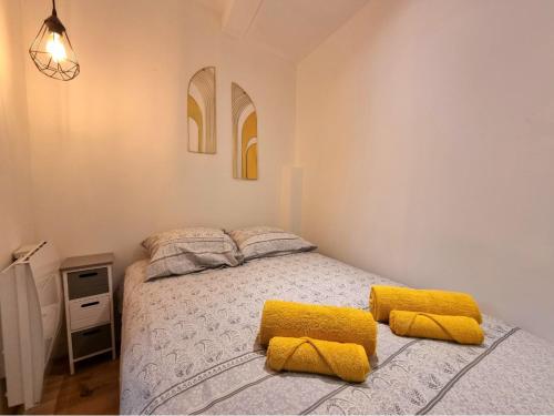 une chambre avec un lit avec des oreillers jaunes dessus dans l'établissement T2 Centre Historique Rénové, à Aix-en-Provence
