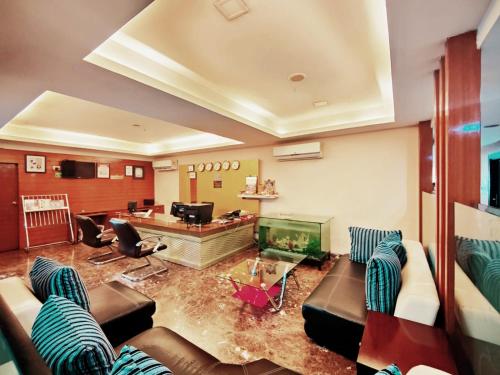 a living room with couches and a fish tank at SWAGATH DE ROYAL HOTEL in Hyderabad
