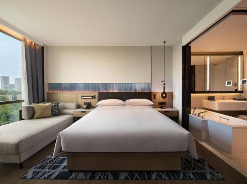 Guangzhou Marriott Hotel Nansha في قوانغتشو: غرفة نوم بسرير ابيض كبير ومغسلة