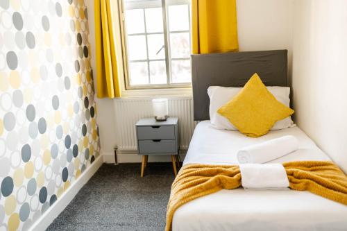 a bedroom with a bed with yellow curtains and a window at Urban Oasis l 3-Bed Gem in Watford Town Center in Watford