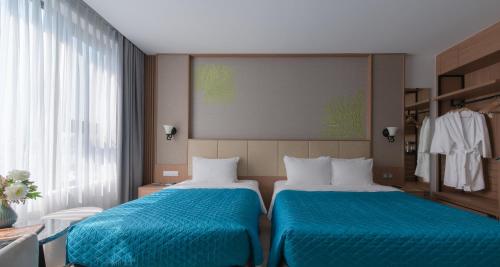 two beds in a hotel room with blue sheets at Navada Beach Hotel in Nha Trang