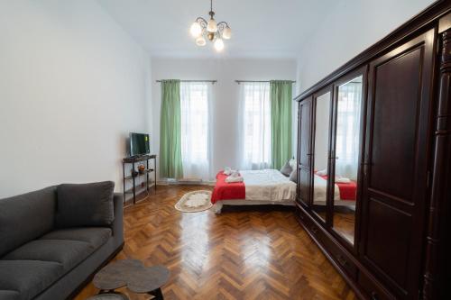 a living room with a couch and a bed at 5* noble house in historic center in Cluj-Napoca