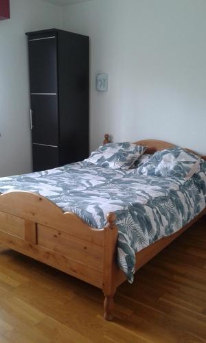 1 cama en un dormitorio con armario negro en Le Bon Accueil, en Val Couesnon