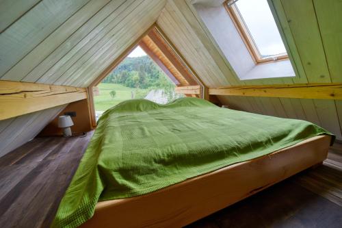 a bed in a room with a large window at Hiša Zdravega Oddiha in Begunje pri Cerknici