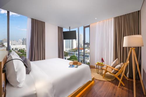 a hotel room with a bed and a large window at Estrella Boutique Hotel in Da Nang