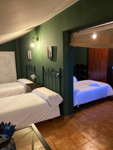 two beds in a room with green walls at Villa Marina in Los Palacios y Villafranca