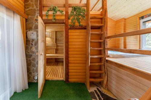 ein Zimmer mit einer Wendeltreppe in einem Blockhaus in der Unterkunft Goričko Relax House in Kuzma
