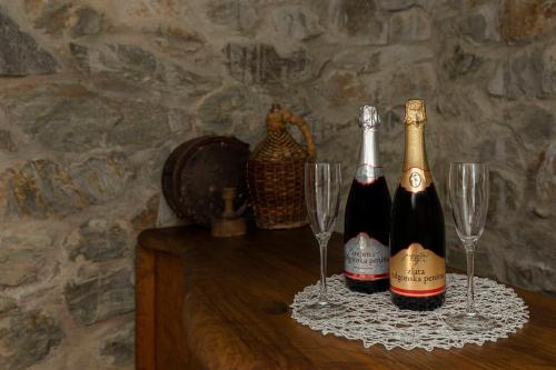 two bottles of champagne and two glasses on a table at Goričko Relax House in Kuzma