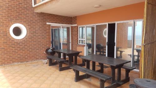 a room with wooden benches and a brick wall at Golden Dawn Chalets in La Mercy