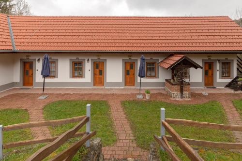 a house with an orange roof and a fence at Goričko Relax House in Kuzma