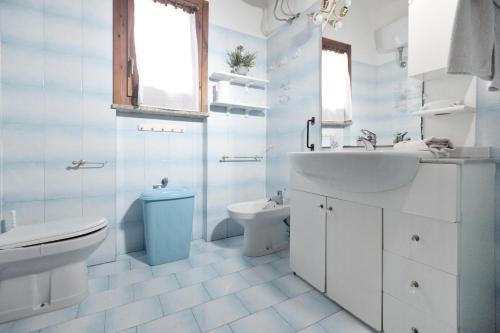 ein weißes Bad mit einem Waschbecken und einem WC in der Unterkunft [Costa Smeralda] Meravigliosa vista sul mare in Cannigione