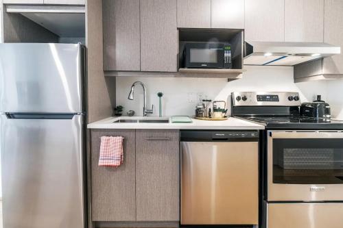 a kitchen with a stainless steel refrigerator and a microwave at Rozenhaus Montreal Hotel in Montréal
