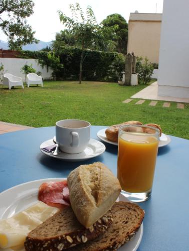 een tafel met een broodje en een kop jus d'orange bij Casa Del Mar Hotel & Apartaments in Roses