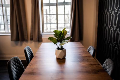 einen Tisch mit einer Topfpflanze, die oben drauf sitzt in der Unterkunft Urban Escape - Stylish 3Bedroom in Watford Center in Watford