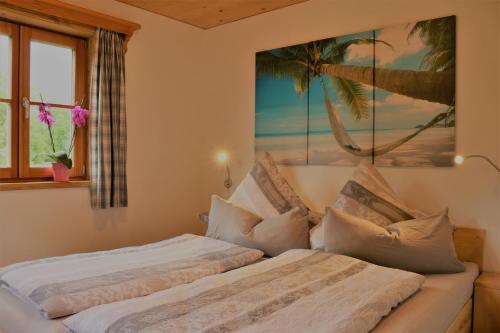 a bedroom with two beds and a painting on the wall at Ferienwohnung Jaud - Gmund am Tegernsee in Gmund am Tegernsee