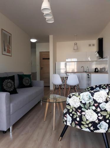 ein Wohnzimmer mit einem Sofa und einem Tisch in der Unterkunft Gościniec Mazurek , Apartament przy Jeziorze Niegocin in Wilkasy