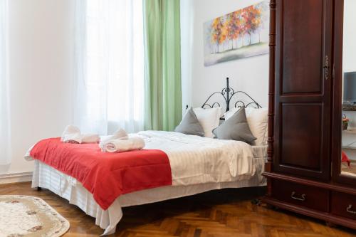 a bedroom with a bed with a red blanket at 5* noble house in historic center in Cluj-Napoca