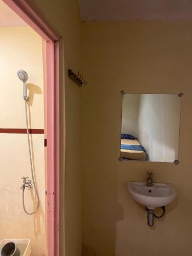 a bathroom with a sink and a mirror at Big Daddy´s Surfcamp in Pasanggaran