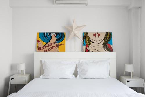 クルジュ・ナポカにあるSpacious ultracentral apartmentのベッドルーム1室(白いベッド1台、上に写真2枚付)