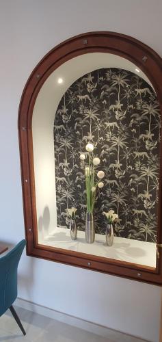 a window with two vases with flowers on a shelf at Hôtel L'Alsace in Narbonne