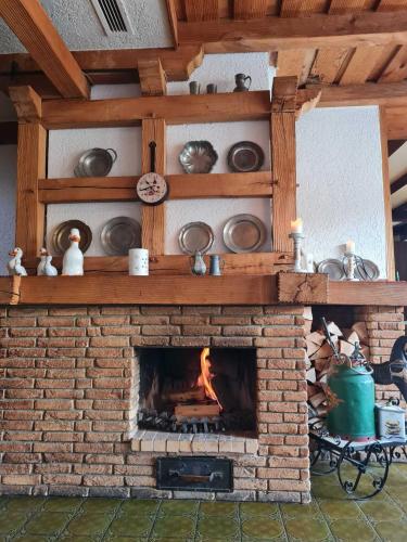 a brick fireplace with a fire in it at Alte Dorfschänke in Kinderbeuern