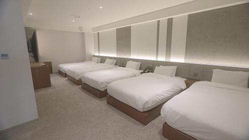 a row of four beds in a room at Interburgo Hotel Wonju in Wonju