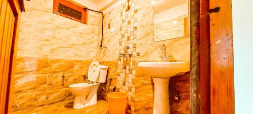 a bathroom with a sink and a toilet at La Vaca India Manali in Manāli