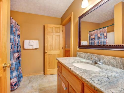 a bathroom with a sink and a mirror at Cub’s Corner, 3 Bedrooms, Pool Access, Hot Tub, Pool Table, Sleeps 10 in Gatlinburg