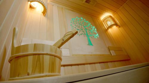 a wooden bucket in a room with a picture of a tree at VELARA HOTEL in Tashkent