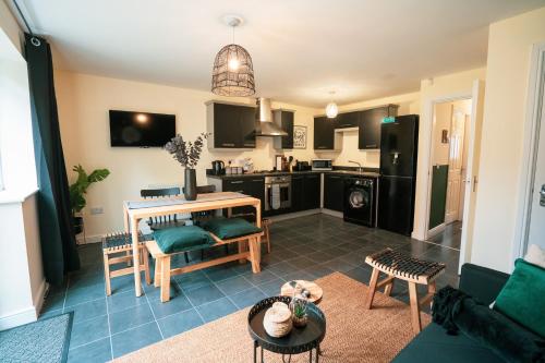 ein Wohnzimmer mit einem Tisch und einer Küche in der Unterkunft Kandaka-Specious Stylish Home - Suitable for Contractors in Killingbeck