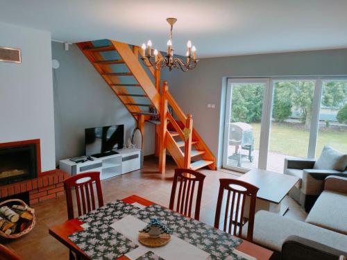 een woonkamer met een trap en een tafel en stoelen bij Apartamenty Beata w Sasinie in Sasino