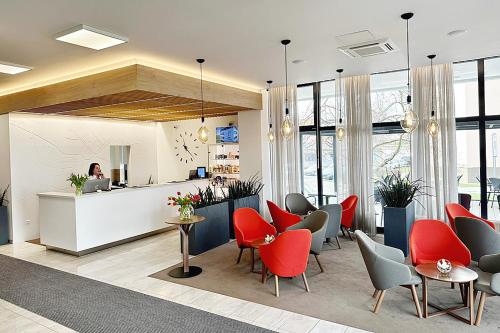 a lobby with red chairs and a counter at Hotel reSTART Superior in Jičín