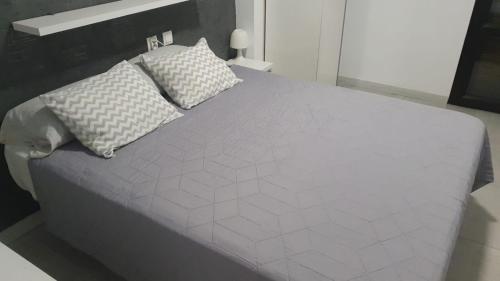 a large white bed with two pillows on it at Piles playa in La Playa de la Torre de Piles