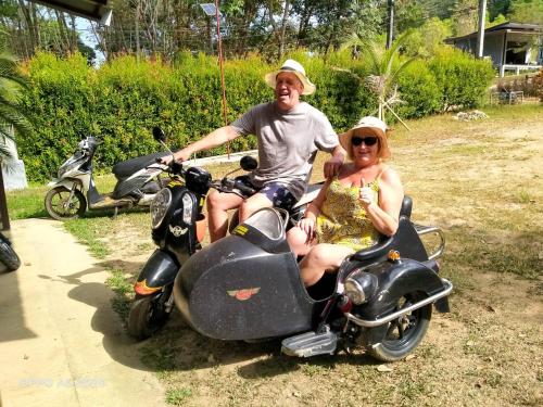 a man and a woman sitting on a scooter at Najjamee Bungalows in Ko Yao Noi