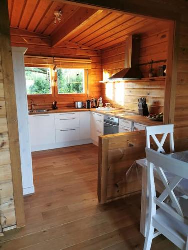 a large kitchen with wooden walls and wooden floors at Chalet am Feldrand in Starzach
