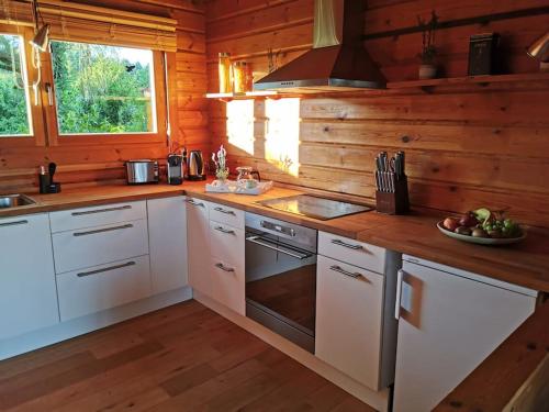 uma cozinha com armários brancos e um fogão em Chalet am Feldrand em Starzach