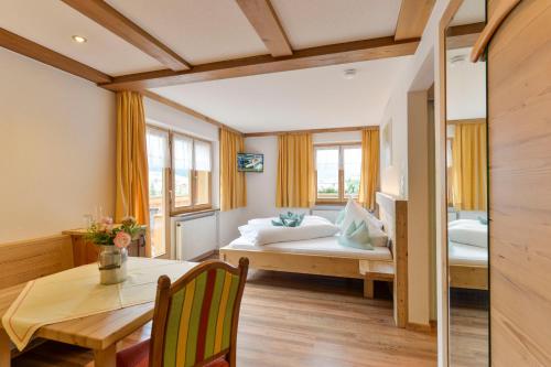 a bedroom with a bed and a table and a dining room at Pension Widderstein in Lech am Arlberg