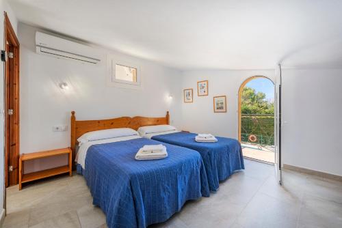 1 Schlafzimmer mit 2 Betten und blauer Bettwäsche in der Unterkunft Villa Ocaso by JS Villas in Port de Pollença