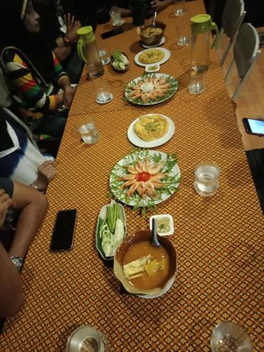 a long table with plates of food on it at Najjamee Bungalows in Ko Yao Noi