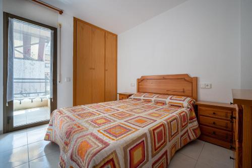 1 dormitorio con 1 cama, vestidor y ventana en AT058 Les Dunes, en Torredembarra