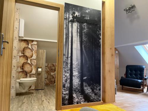 baño con puerta corredera y mural forestal en Apartament w stylu Loft, en Spała