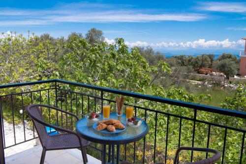 stół z talerzem jedzenia na balkonie w obiekcie Amarandos Studios with swimming pool by Imagine Lefkada w mieście Tsoukalades