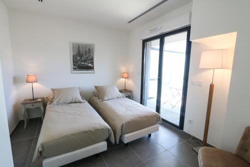 カンヌにあるUnique a Cannesの大きな窓付きの客室で、ベッド2台が備わります。