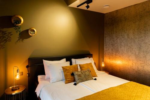 een slaapkamer met een bed met witte lakens en gele kussens bij Bed en breakfast Suite 8 in Langenboom