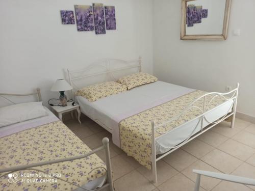 a bedroom with two beds and a table and a mirror at Boni02 in Gdinj