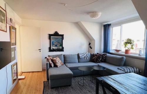 a living room with a blue couch and a table at Stege Torv Family Apartment in Stege