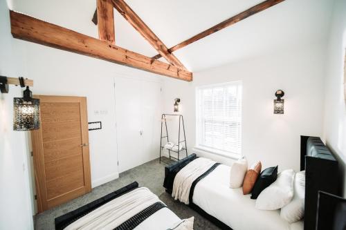 a white bedroom with two beds and a window at Kandaka-Peaceful House in Roundhay