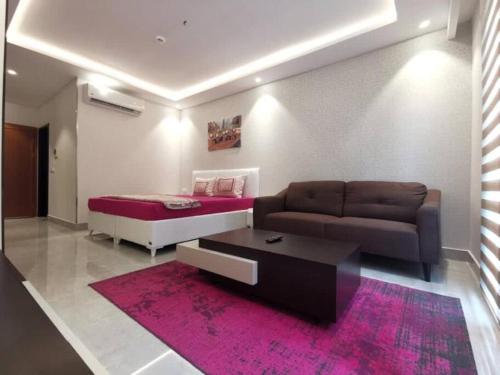 een woonkamer met een bank en een bed bij Intimate Studio Apartment - Mirage Residence in Accra