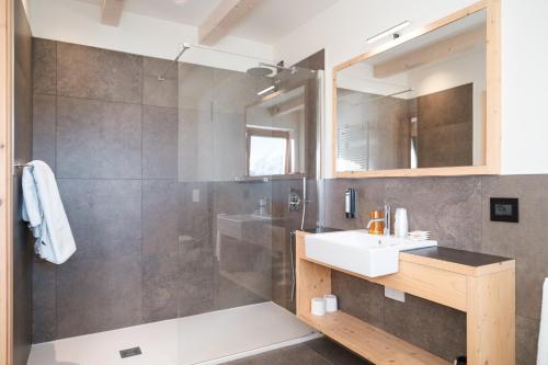 y baño con ducha, lavabo y espejo. en Hotel Piccola Baita en Molveno