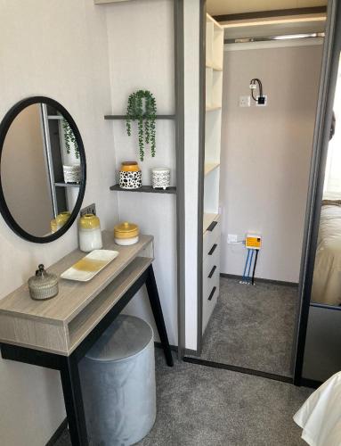 a bathroom with a vanity with a mirror and a sink at Bailey Lodge in Padstow